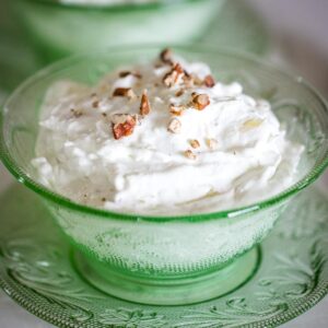 closeup of watergate salad in bowl topped with pecans