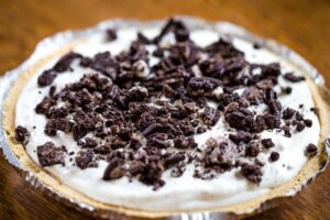 pie filling topped with oreos in graham cracker crust