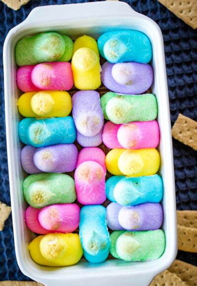 peeps smores dip in baking dish surrounded by graham crackers