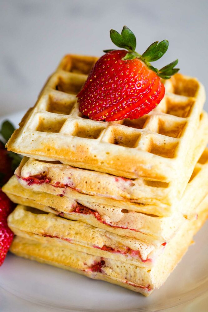 top view of strawberry waffles on plate topped with strawberry