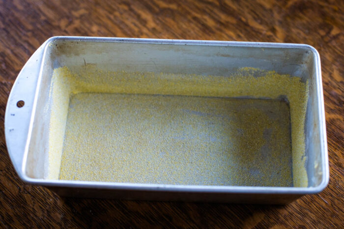 bread pan prepped with grease and corn meal