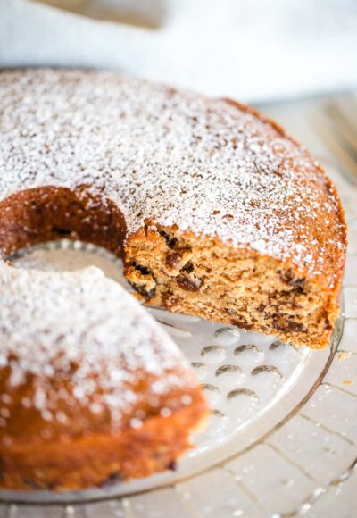raisin cake on serving plate dusted with powdered sugar