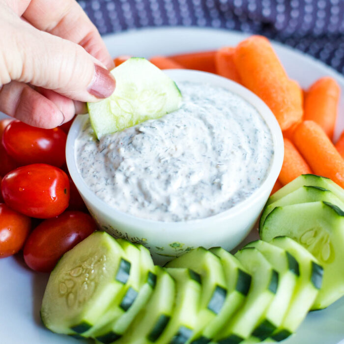 dipping cucumber into veggie dip