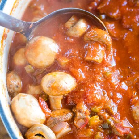 scooping mushroom stew out of large stock pot