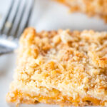 side view of apricot bars on plate with fork
