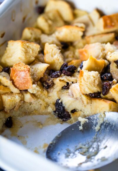 bread pudding in baking dish with large serving spoon