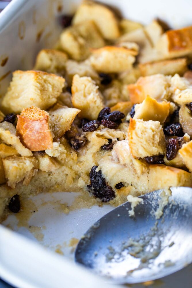 bread pudding in baking dish with large serving spoon