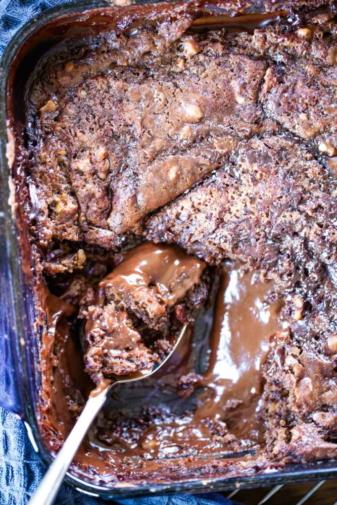 brownie pudding in baking pan with spoon
