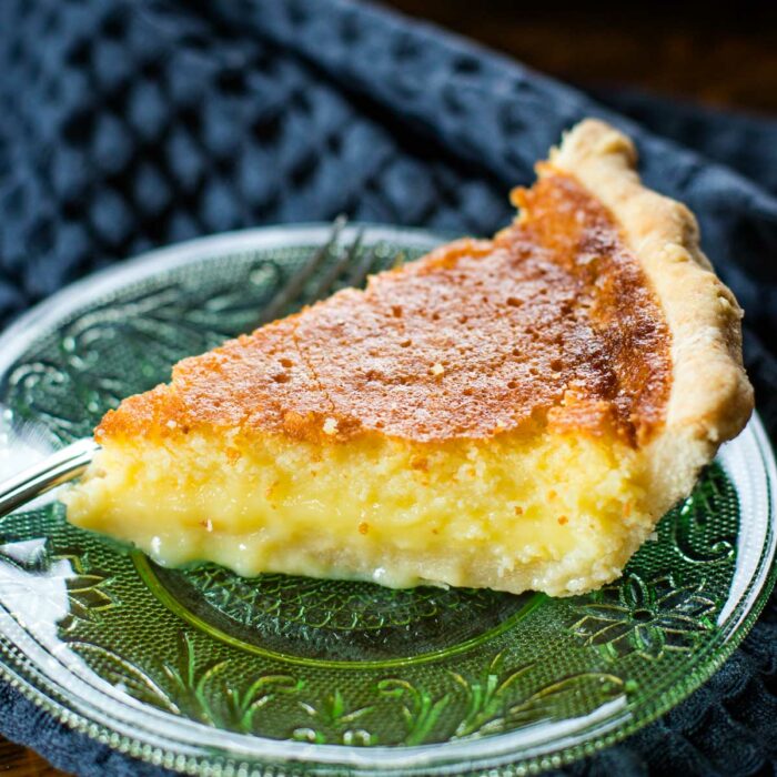 close up of slice of buttermilk pie on plate with fork