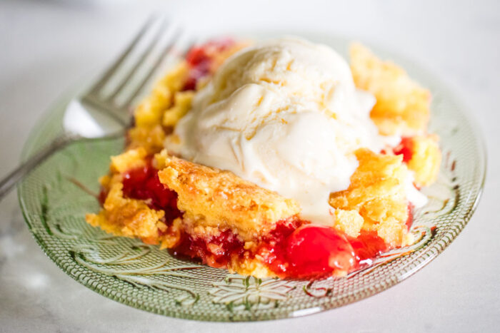 cherry dump cake on plate with fork