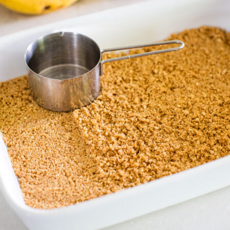 pressed graham cracker crust with measuring cup