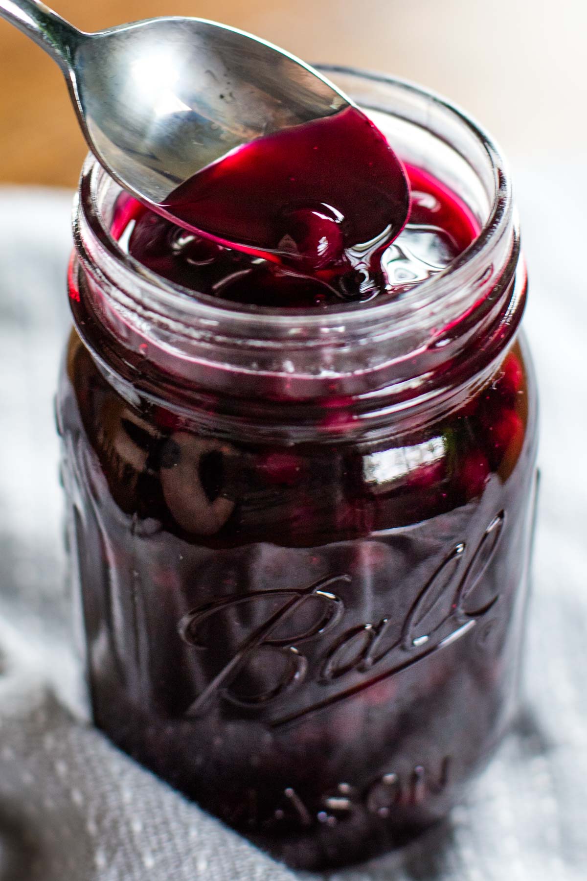 spoon scooping into jar with blueberry syrup