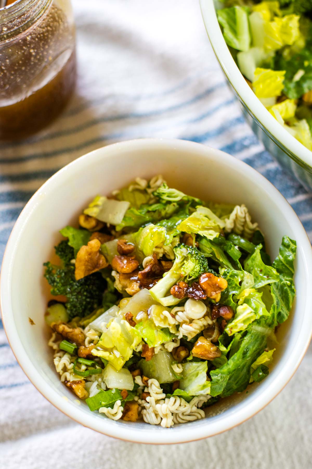 romaine salad in bowl with dressing beside it