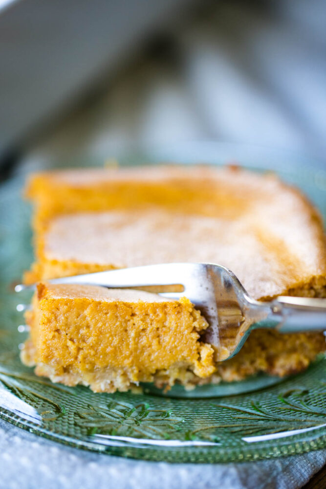 pumpkin cheese cake bar slice on plate with forking cutting bite
