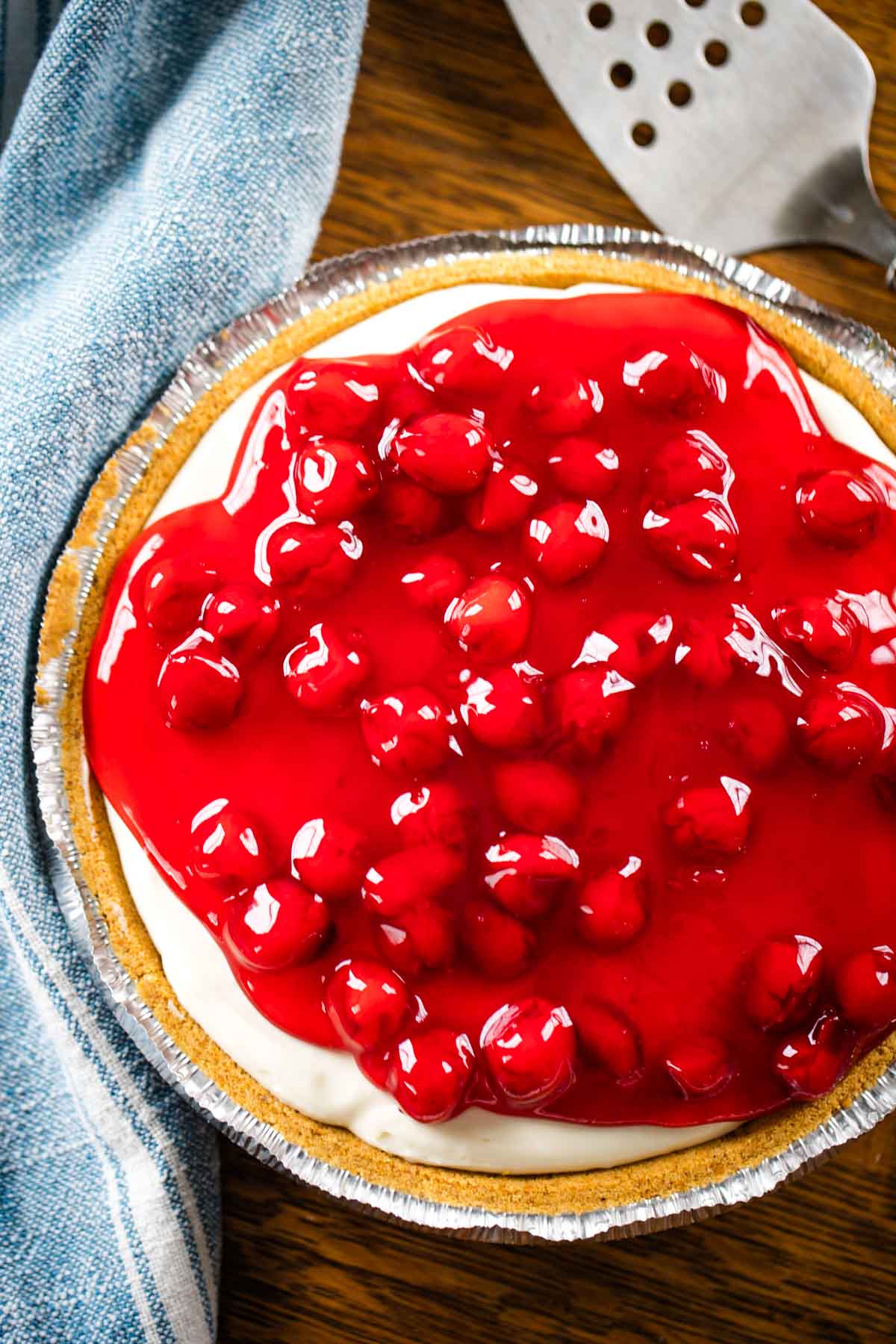 cherry cream cheese cake with pie server on kitchen table