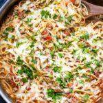 taco spaghetti in large skillet with wooden serving spoon
